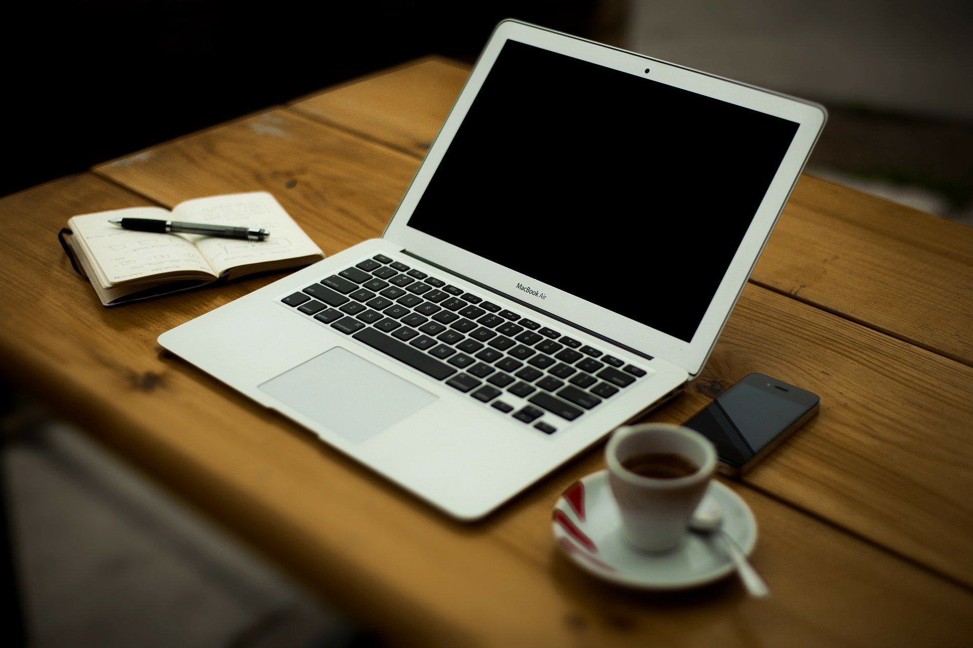Ein Schreibtisch mit einem Laptop und einer Kaffeetasse