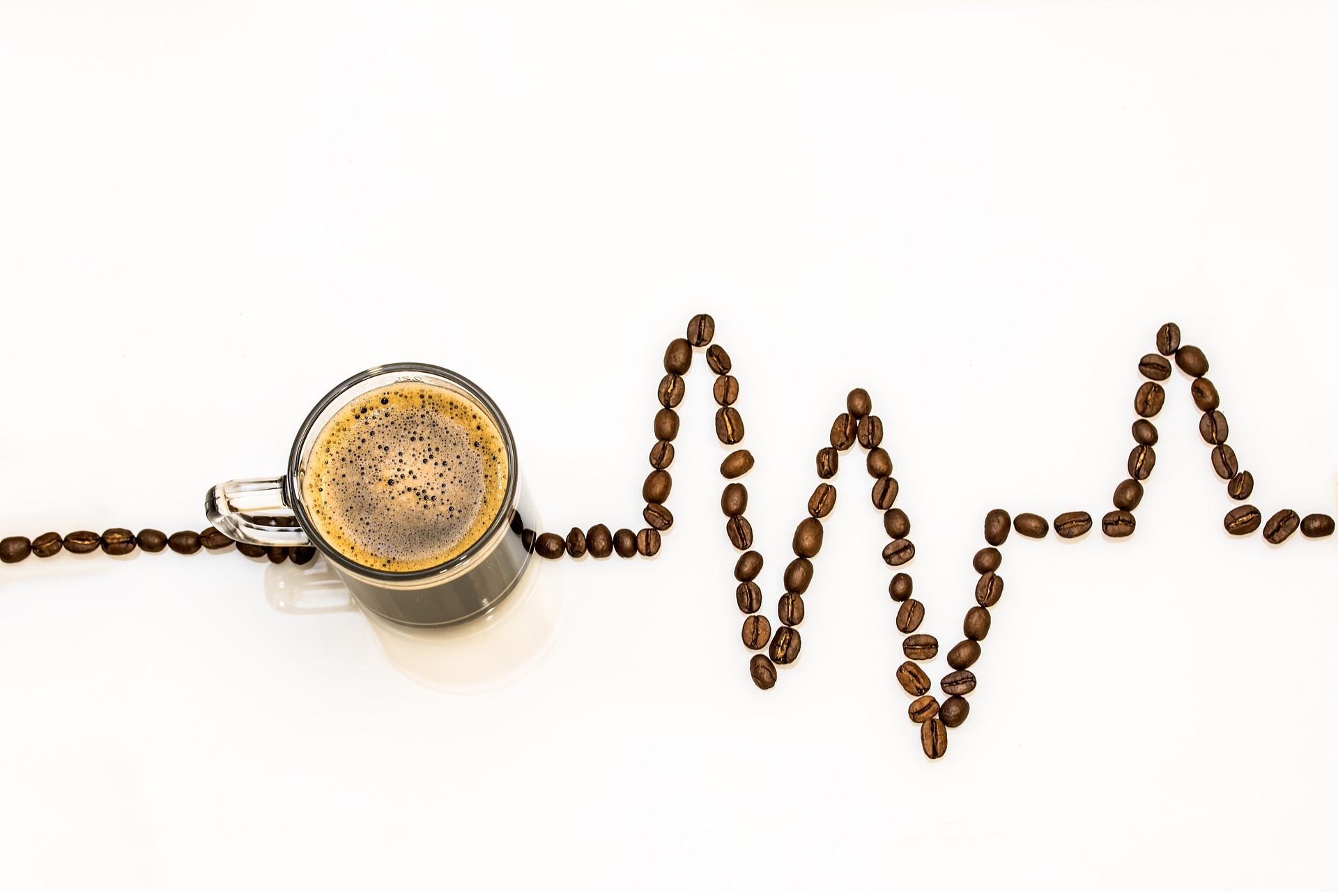 Eine Kaffeetasse und ein Herzfrequenzbild aus Bohnen gezeichnet